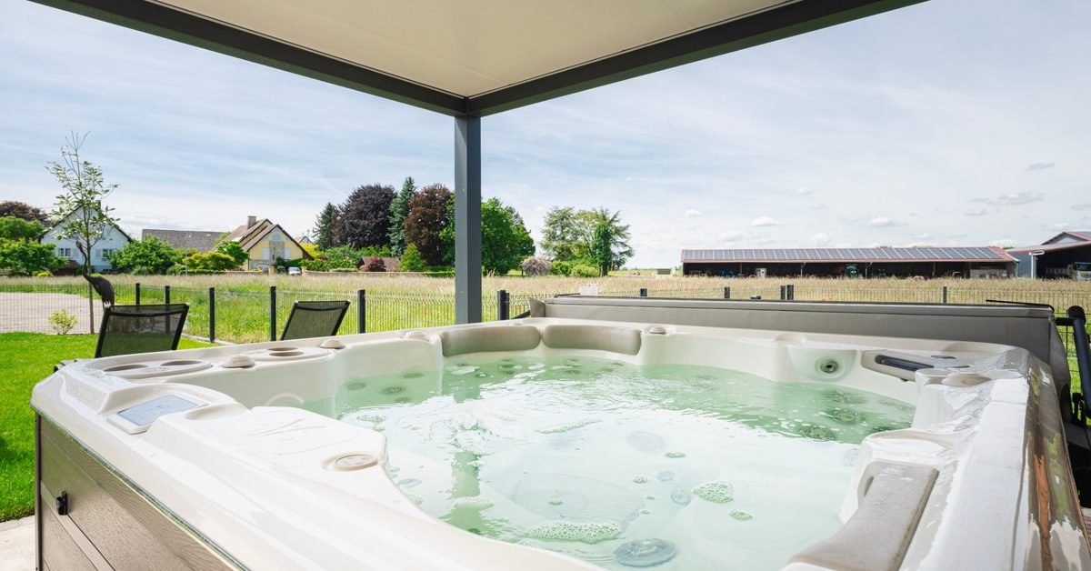 Jacuzzi sous une pergola avec vue sur les champs, logement La Moutonneraie en Alsace